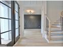 Bright entryway with hardwood floors, modern staircase, and dark accent wall at 115 Grace Hope Dr, Brooks, GA 30205