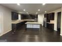Spacious kitchen with dark cabinets, granite countertops, and stainless steel appliances at 566 Mariposa Ln, Mcdonough, GA 30253