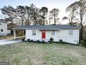 Ranch house with red door, carport, and lush green lawn at 3809 Clovis Nw Ct, Atlanta, GA 30331