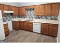 Well-equipped kitchen featuring wood cabinets and tile backsplash at 2395 Brianna Dr, Hampton, GA 30228