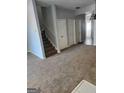 Open living area with carpet, staircase, and neutral walls at 2395 Brianna Dr, Hampton, GA 30228