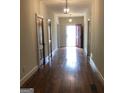 Long hallway with hardwood floors and red door at 2095 Sw Flat Shoals Rd, Conyers, GA 30094