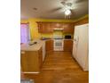 Kitchen with light oak cabinets and hardwood floors at 50 Riverside Ct, Hampton, GA 30228