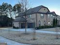 Brick home with a three-car garage and a large driveway at 2801 Karras Cv, Hampton, GA 30228