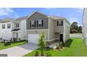 Two-story house with gray siding, a two-car garage, and landscaping at 11996 Conrad Cir # 128, Hampton, GA 30228