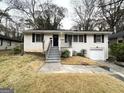Brick ranch home with a front porch, attached garage, and grassy yard at 2816 Cloverhurst Dr, East Point, GA 30344
