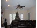 Living room featuring a sectional sofa, Christmas tree, and ceiling fan at 732 Country Lake Drive Dr, Hampton, GA 30228