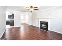 Living room featuring hardwood floors, fireplace, and view into kitchen at 4626 Derby Loop, Fairburn, GA 30213
