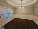 Formal dining room features dark hardwood floors and wainscoting at 1241 St James Pl, Loganville, GA 30052