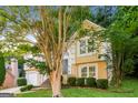 Two-story house with tan exterior, two-car garage, and landscaping at 1949 Greensbrooke Close, Stone Mountain, GA 30088