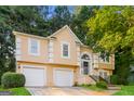 Two-story house with tan exterior, two-car garage, and manicured lawn at 1949 Greensbrooke Close, Stone Mountain, GA 30088