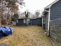 View of the back of the house, showing a detached structure and a chain link fence at 2724 Bomar Rd, Douglasville, GA 30135