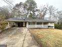 Brick ranch home with carport, covered porch, and a spacious yard at 3975 Phylis Pl, Decatur, GA 30035