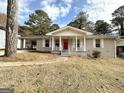 Brick ranch house with red front door, covered porch, and landscaped yard at 1914 Janet Ln, Decatur, GA 30035