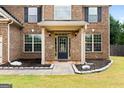 House entrance with a dark-stained door and brick columns at 289 Astoria Way, Mcdonough, GA 30253