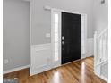 Elegant entryway with hardwood floors and a black front door at 427 Blackbird Way, Hampton, GA 30228