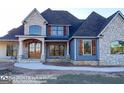 Two-story house with stone and blue siding, a covered porch, and landscaping at 120 National Way, Carrollton, GA 30116
