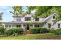 Two-story white farmhouse with wrap-around porch at 2398 Maddox Rd, Buford, GA 30519