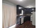 Dark wood kitchen with white appliances and vinyl flooring at 650 Lowell Sw Dr, Marietta, GA 30008
