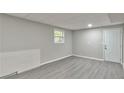 Finished basement room with grey laminate flooring and an exterior access door at 2592 Candler Woods Dr, Decatur, GA 30032
