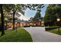 Elegant stone manor on a sprawling estate with a long brick driveway and manicured landscaping at 4665 Riverview Rd, Atlanta, GA 30327