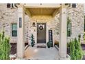 Inviting front entry with a large door and a covered porch at 1025 Fable Ln, Hampton, GA 30228