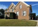 Brick two-story house with stone accents and landscaped yard at , , GA 30019