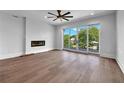 Spacious living room with hardwood floors, fireplace, and access to balcony at 8212 Main St # 1202, Woodstock, GA 30188