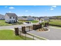 Gated community entrance with landscaped areas and open green space at 11964 Conrad Cir, Hampton, GA 30228