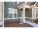 House entrance with a light green exterior, stone accents, and a white door at 1010 Franklin Cv, Austell, GA 30106