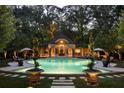 Elegant pool and cabana with lighting, landscaping, and patio furniture at 4665 Riverview Rd, Atlanta, GA 30327