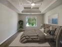 Virtually staged main bedroom with tray ceiling and large window at 5789 Wellborn Creek Dr, Lithonia, GA 30058