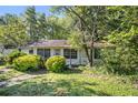 Small white house with overgrown landscaping at 2472 Perry Nw Blvd, Atlanta, GA 30318