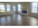 Spacious living room featuring hardwood floors, fireplace, and multiple windows at 716 Vireo Walk, Loganville, GA 30052