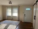 Living room with hardwood floors, new interior door, and updated light fixture at 1433 Woodland Sw Ter, Atlanta, GA 30311