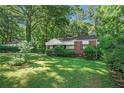 Brick ranch house with a large yard and mature trees at 2576 Godfrey Nw Dr, Atlanta, GA 30318