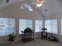 Bright sunroom with vaulted ceiling, multiple windows, and seating area at 6133 Malloway Ct, Cumming, GA 30041