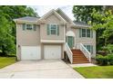 Two-story house with two-car garage, wooden stairs and green shutters at 3364 Joseph Nw Dr, Acworth, GA 30101