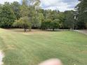 Large grassy lot with mature trees and a gentle slope at 4616 Lenora Church Rd, Snellville, GA 30039