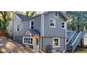 Gray house with a wooden deck and stairs, a partial view of a fenced yard, and a driveway at 1902 Canterbury St, Decatur, GA 30032