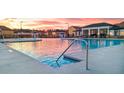 Resort-style pool with a sundeck and surrounding community homes at sunset at 3219 Champions Way, Loganville, GA 30052