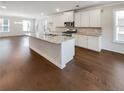 Kitchen with island, hardwood floors, and white cabinets at 2286 Foley Park St, Snellville, GA 30078