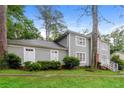 Two-story house with gray siding, a brick foundation, and a landscaped yard at 2848 Creekwood Dr, Snellville, GA 30078