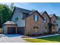 Two-story home with brick and siding, two-car garage, and landscaped yard at 557 Saltbox Ln, Mcdonough, GA 30252