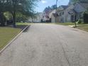 View of a residential street with houses, lawns, and sidewalks at 7015 Setters Way, Lithonia, GA 30038