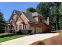 Brick home with a three-car garage and manicured lawn at 319 Summer Garden Dr, Marietta, GA 30064