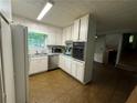 Bright kitchen with white cabinets, stainless steel appliances, and tile floor at 612 Mincey Woods Ct, Stone Mountain, GA 30087