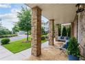 Inviting front porch with stone columns, a swing, and comfortable seating at 7445 Cordery Rd, Cumming, GA 30040