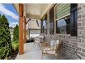 Relaxing front porch with wicker chairs and brick exterior at 4397 Waxwing St, Hoschton, GA 30548