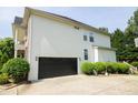 Two-car garage with black doors and a side yard at 249 Chadwyck Ln, Canton, GA 30115